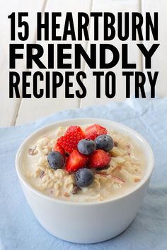 a bowl of oatmeal with strawberries and blueberries in the middle