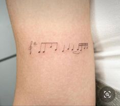 a tattoo with musical notes on it