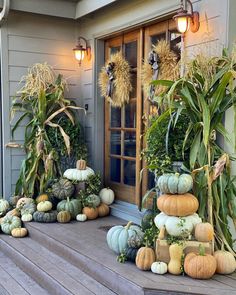 the front porch is decorated with pumpkins and gourds