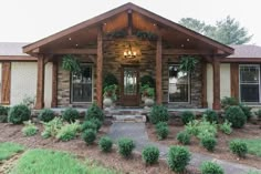 a house that is made out of wood and stone with plants on the front porch