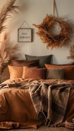 a bed with pillows, blankets and wreaths on the headboard in a bedroom