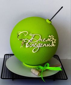 there is a green ball on top of a plate with the word boogeous written on it