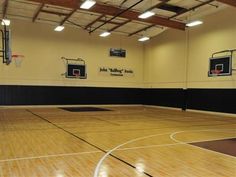 an indoor basketball court with wooden floors and lights