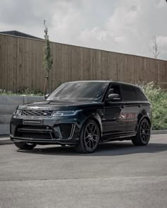 a black range rover parked in front of a building