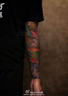 a man's arm with tattoos on it and his hand holding the other arm