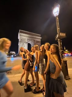 a group of young women standing next to each other in front of a street light