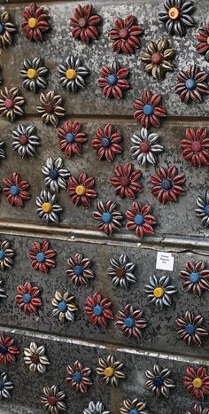 several red, white and blue pinwheels are arranged in rows on a metal surface