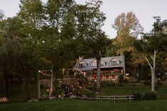 a large house surrounded by trees in the evening