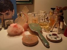 an assortment of beauty products on a table next to a doll and other items from the collection