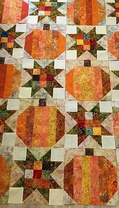 an orange and yellow quilt is laying on the floor