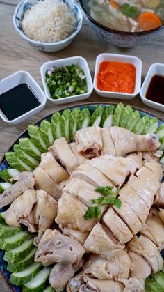 a plate filled with chicken and vegetables next to dipping sauces