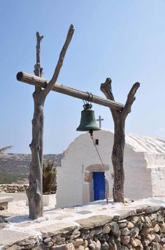 an old church with a bell in front of it