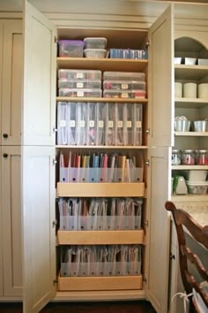 an organized pantry with clear plastic containers on the bottom shelf and shelves full of other items