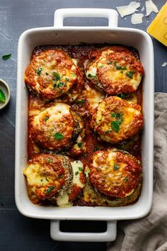 a casserole dish with meat and cheese in it on a blue tablecloth