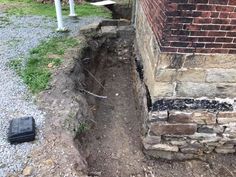 an old brick building with a hole in the ground that has been dug into it