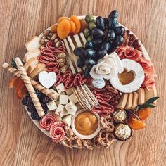 a platter filled with different types of cheeses, meats and crackers