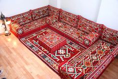 a red couch sitting on top of a wooden floor