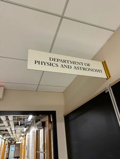 a sign that says department of physics and astronomy hanging from the ceiling