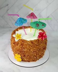 there is a cake with straw and umbrellas on it that has flowers in the middle