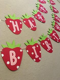 some strawberries are hanging on a string with the words happy birthday written on them