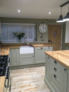 a kitchen with an oven, sink and clock on the wall in it's center