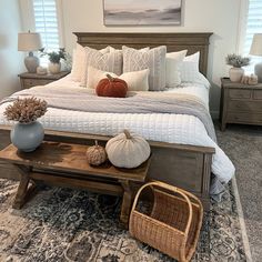 a bedroom with a large bed and two baskets on the end tables in front of it