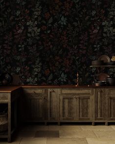 a kitchen with wooden cabinets and black wallpaper