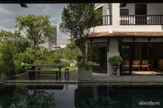 a house with a pool in front of it and some chairs on the other side