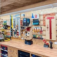 a workbench with lots of tools on the wall and shelves filled with items