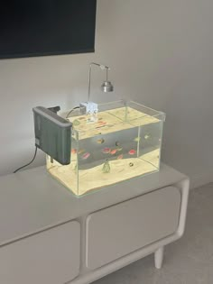 a fish tank sitting on top of a white dresser