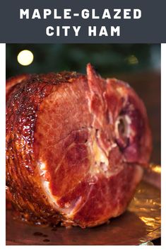 a piece of ham sitting on top of a wooden cutting board next to a christmas tree