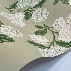 the wall paper has white flowers and green leaves on it