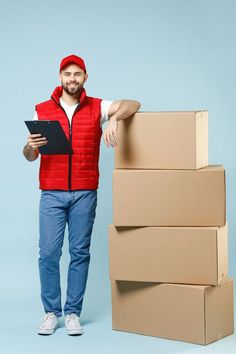 a man standing next to stacks of boxes and holding a clipboard in his hand