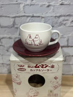 a cup and saucer sitting on top of a box