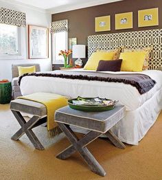 a bed room with a neatly made bed next to a table and chairs in front of a window