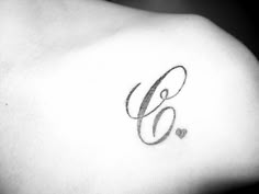 the upper half of a woman's shoulder with an initial letter g on it