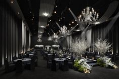 an elegant black and white wedding reception with chandeliers, table linens, and centerpieces