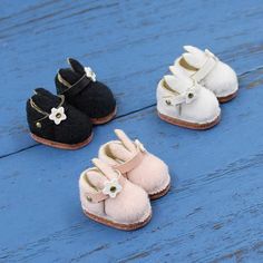 four pairs of baby shoes sitting on top of a blue wooden floor next to each other