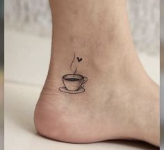 a small tattoo on the foot of a woman with a cup of coffee in it