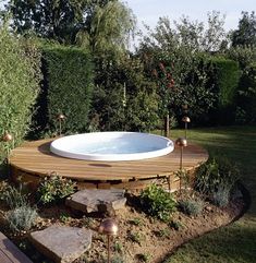 a hot tub in the middle of a garden