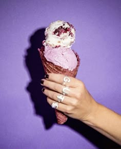 a woman's hand holding an ice cream cone