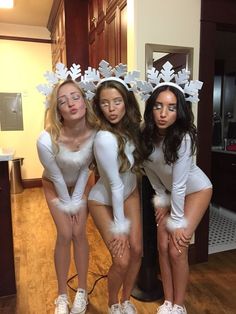 three women in white costumes posing for the camera with their hands on their hipss