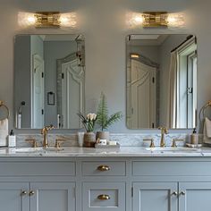 a bathroom with double sinks and two mirrors on the wall next to eachother