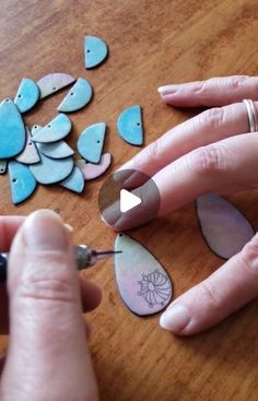 a woman is cutting up some paper hearts on a wooden table with scissors and glue