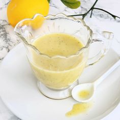 a glass pitcher filled with liquid sitting on top of a white plate next to an orange