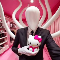 a man in a suit holding a hello kitty doll with pink walls and white swirls behind him