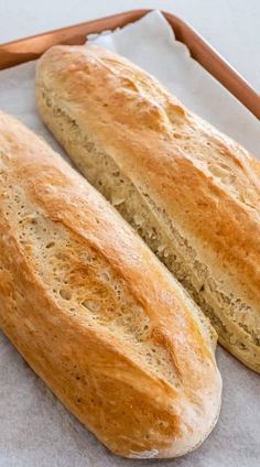 two loaves of bread sitting on top of a piece of paper