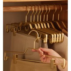 a person's hand is pointing at some clothes hanging on a rack