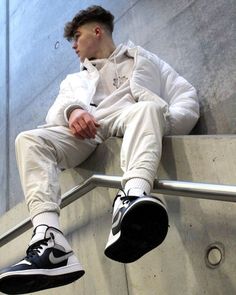 a man sitting on top of a metal rail