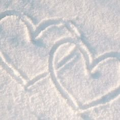 a heart drawn in the snow on a white surface